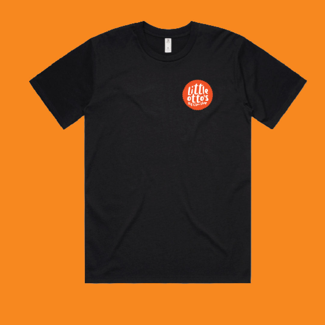 A black short-sleeve crewneck t-shirt with a small circular red and white graphic on the left chest, displayed flat against a solid orange background.