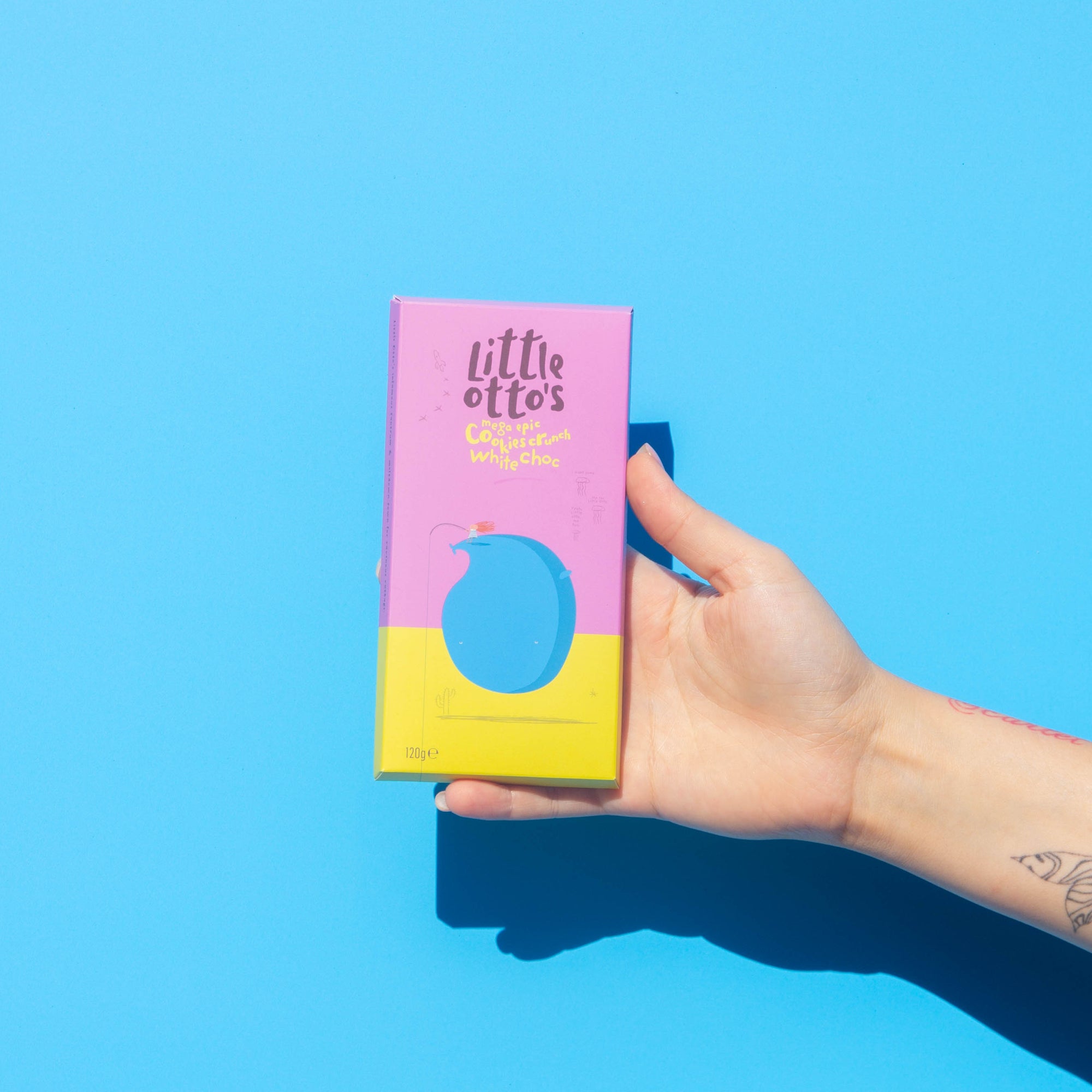 Little Otto's Chocolate bar White Chocolate and Cookies Crunch nfront of Busselton blue wall