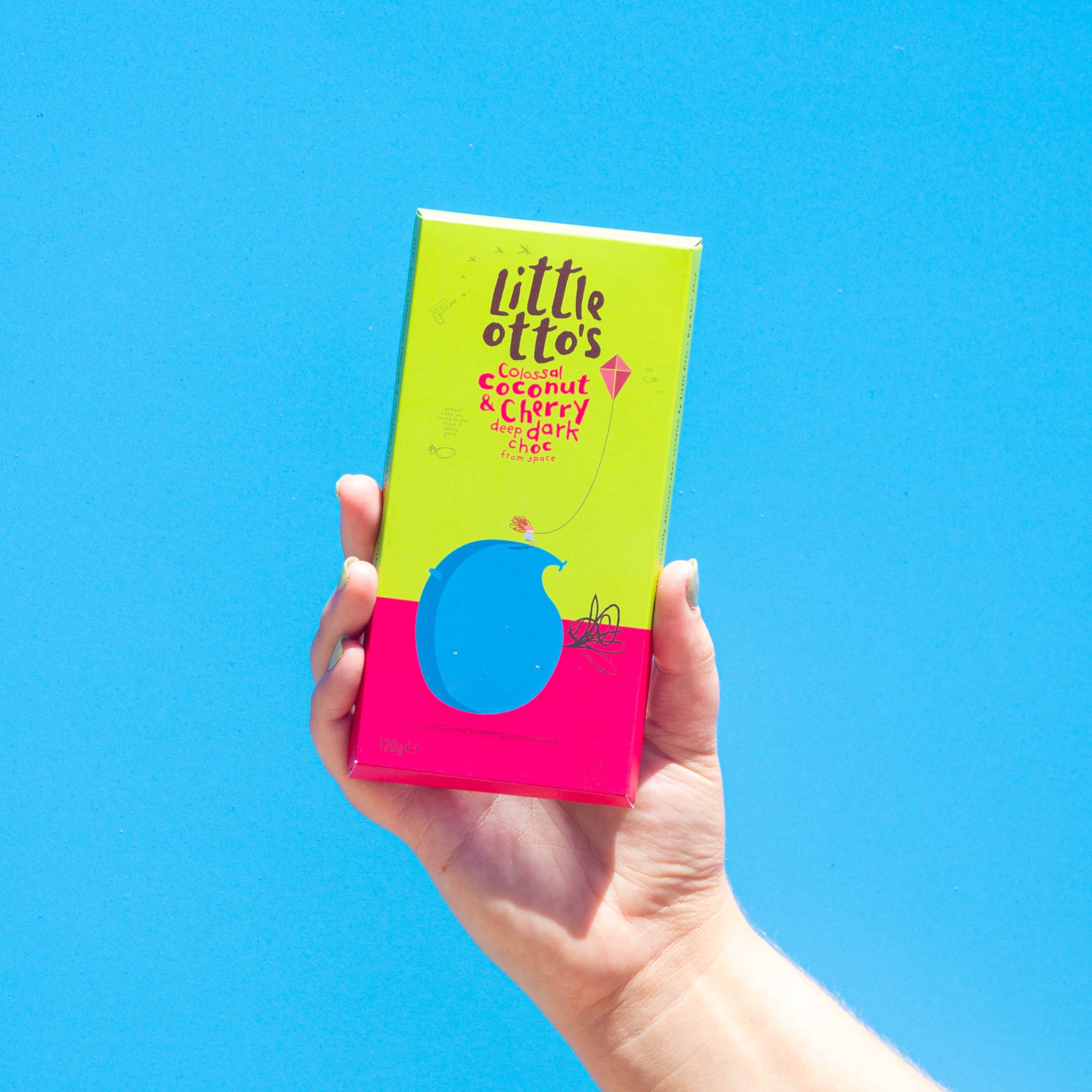  Little Otto's Coconut & Cherry Dark Chocolate Infront of Busselton blue wall