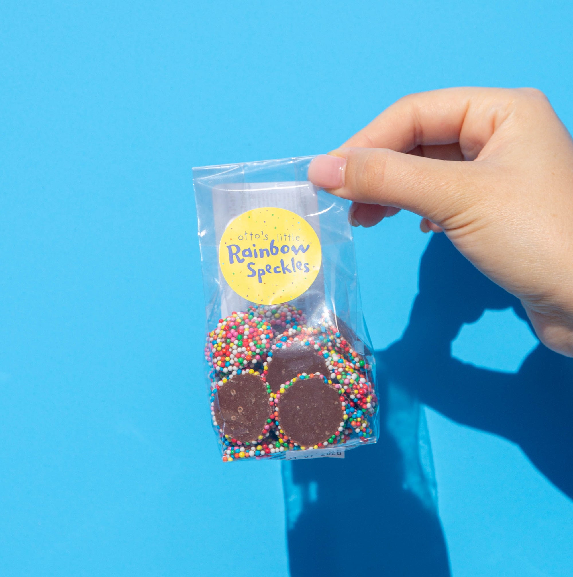Little Otto's Staff holding Little Rainbow Speckles 100g infront of Busselton blue wall