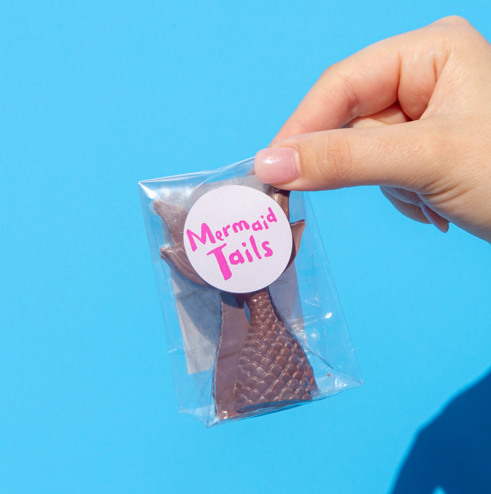 Little Otto's Staff holding Milk Chocolate Mermaid Tail infront of Busselton blue wall