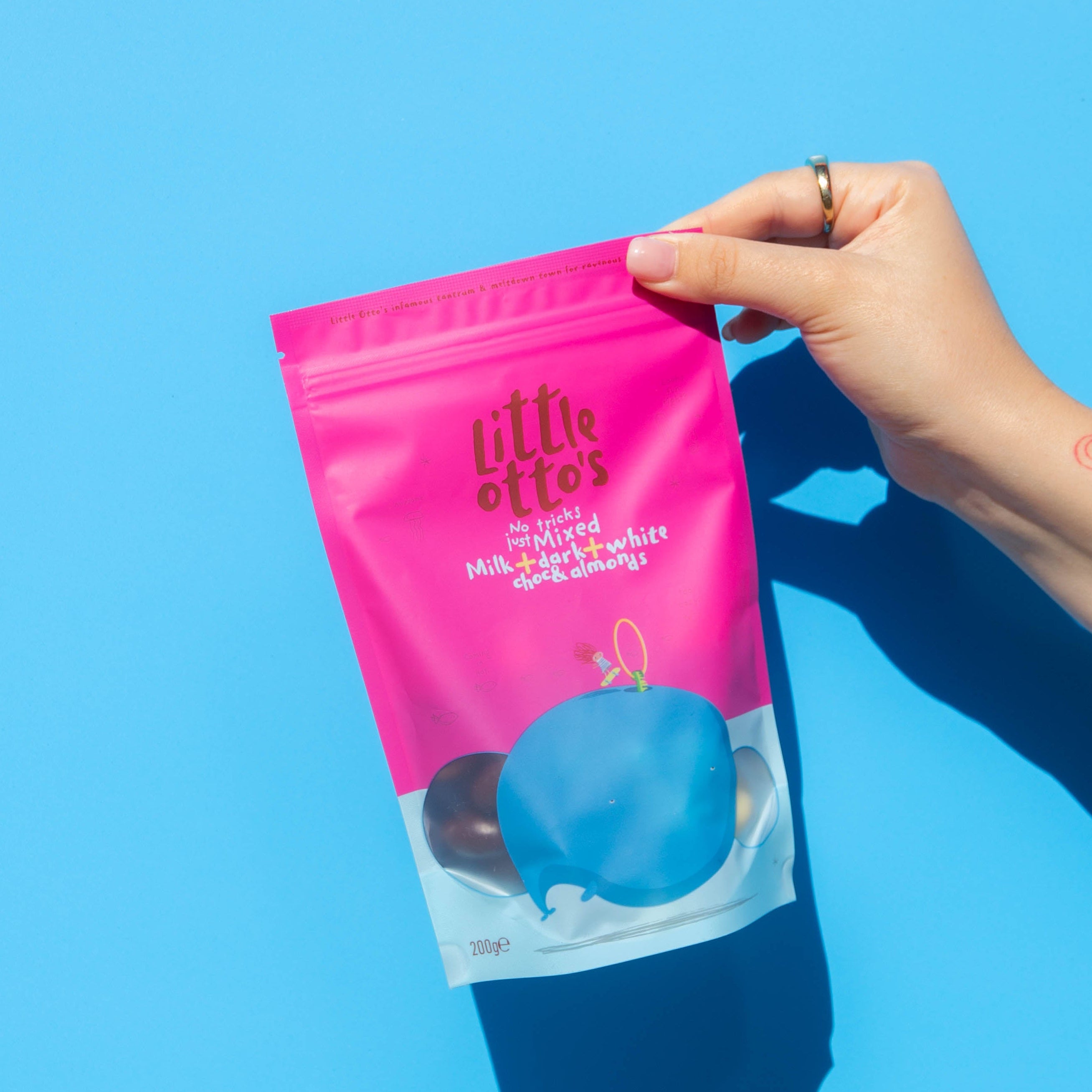 Little Otto's Staff holding Mixed Chocolate Almonds 200g Infront of Busselton blue wall