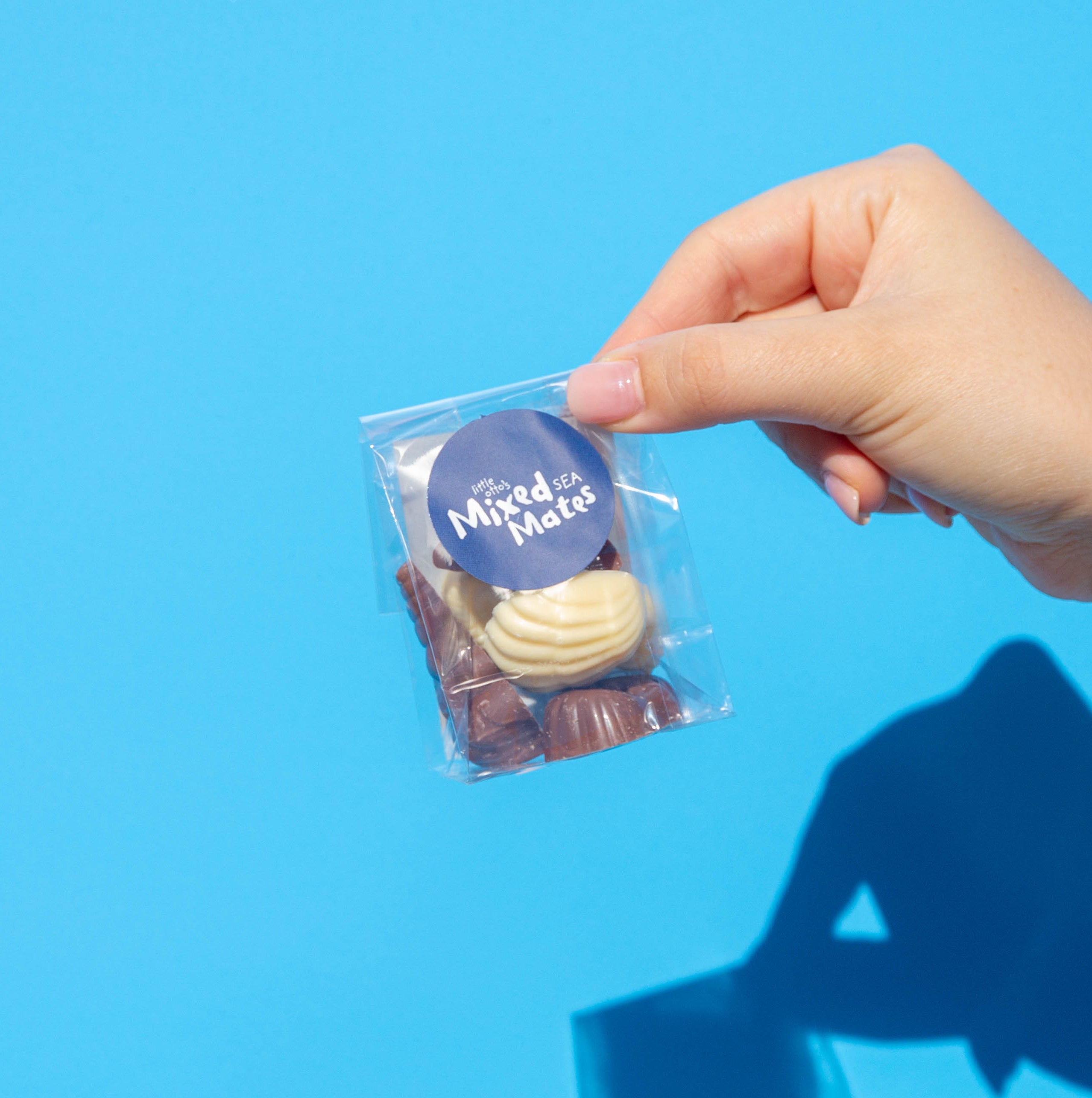 Little Otto's Staff holding Mixed Chocolate Little Ottos Sea Mates infront of Busselton blue wall