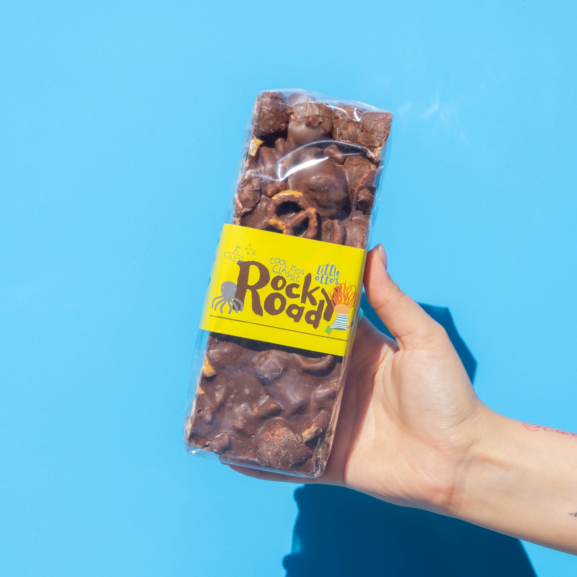 Little Otto's Staff holding Rocky Road to Love 500g infront of Busselton blue wall