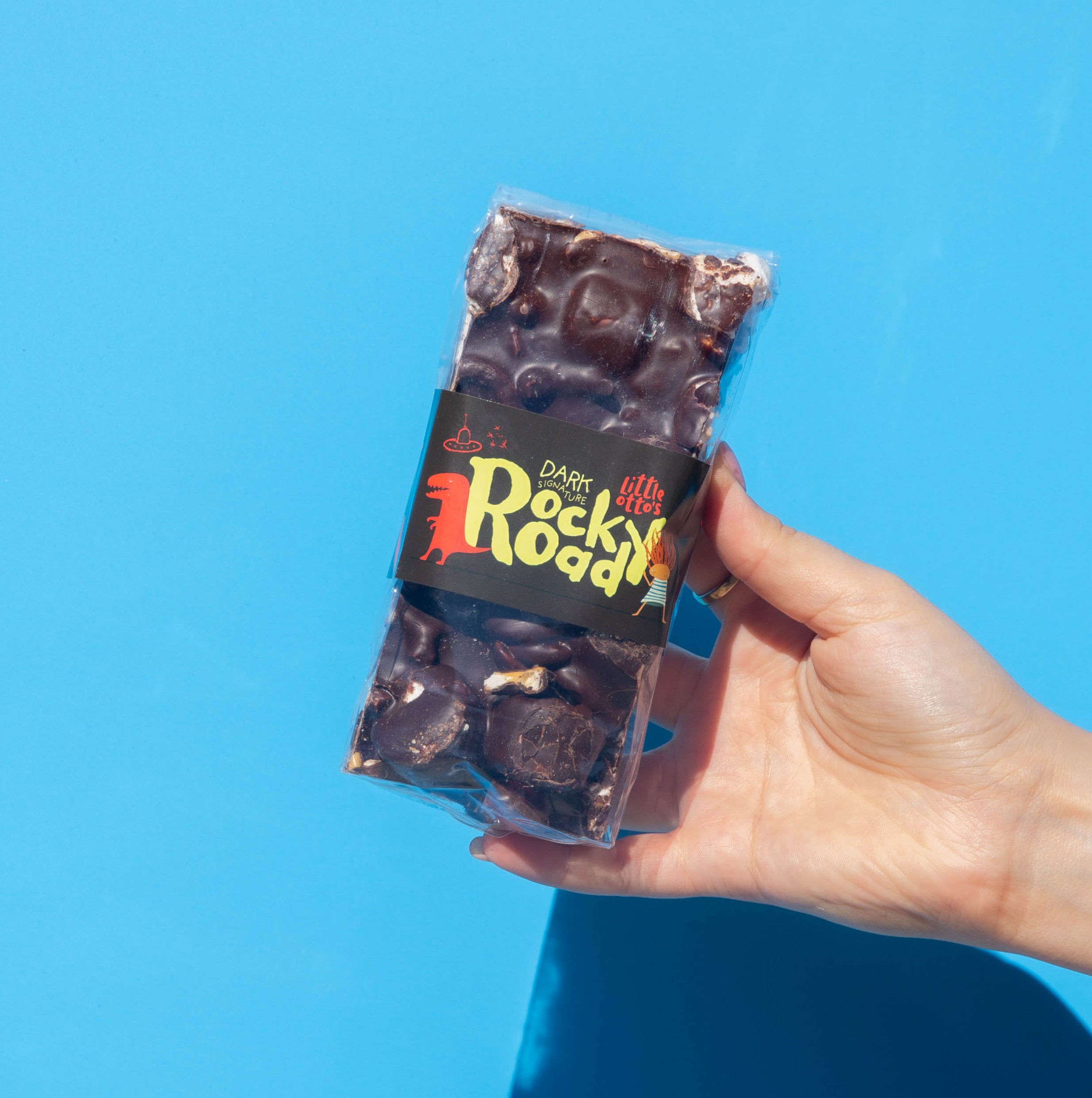 Little Otto's Staff holding Dark Signature Rocky Road 340g infront of Busselton blue wall