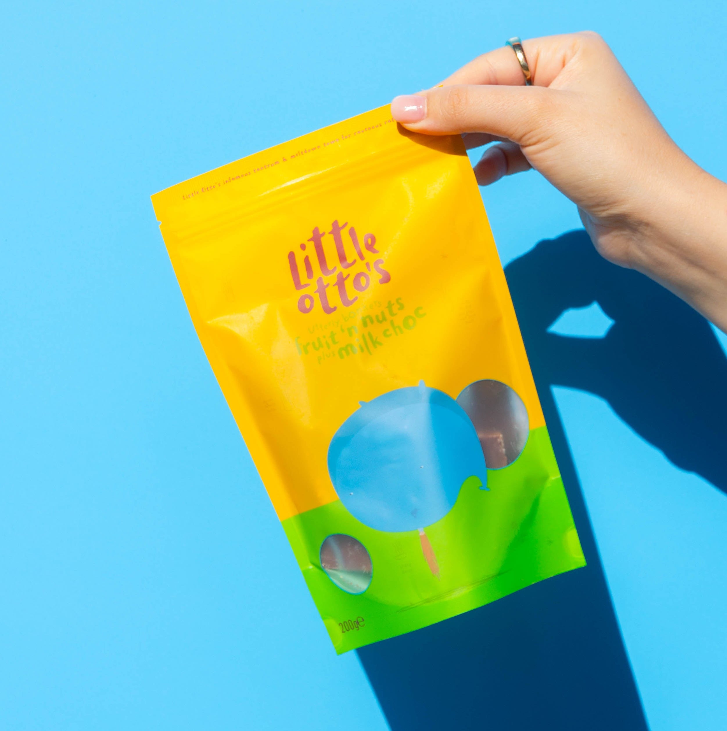 Little Otto's Staff holding Fruit n nut milk choc infront of Busselton blue wall