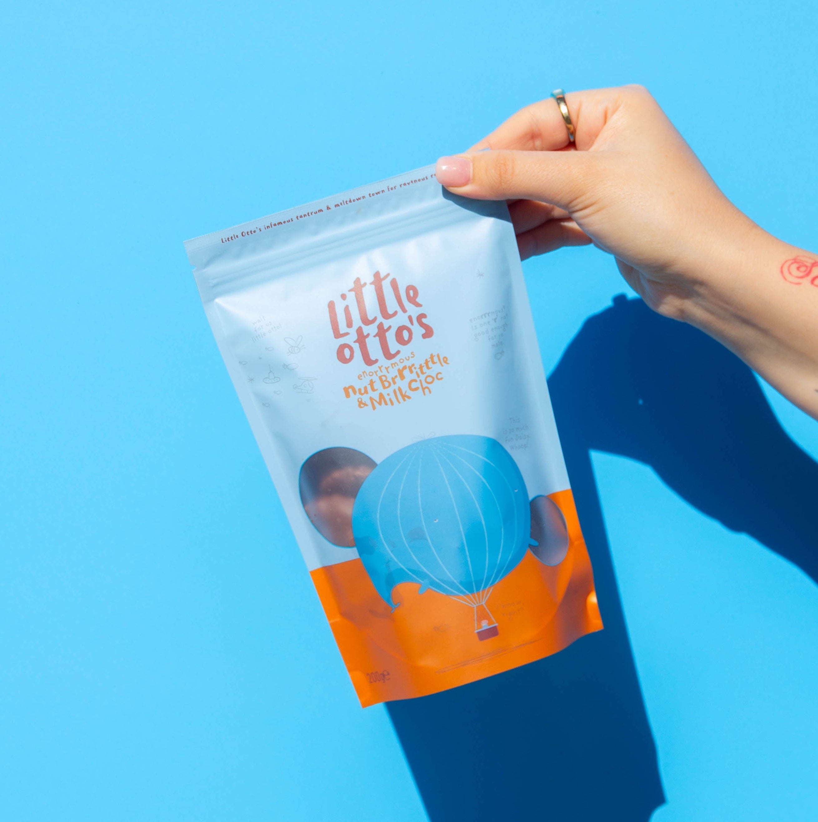 Little Otto's Staff holding Nut Brittle infront of Busselton blue wall