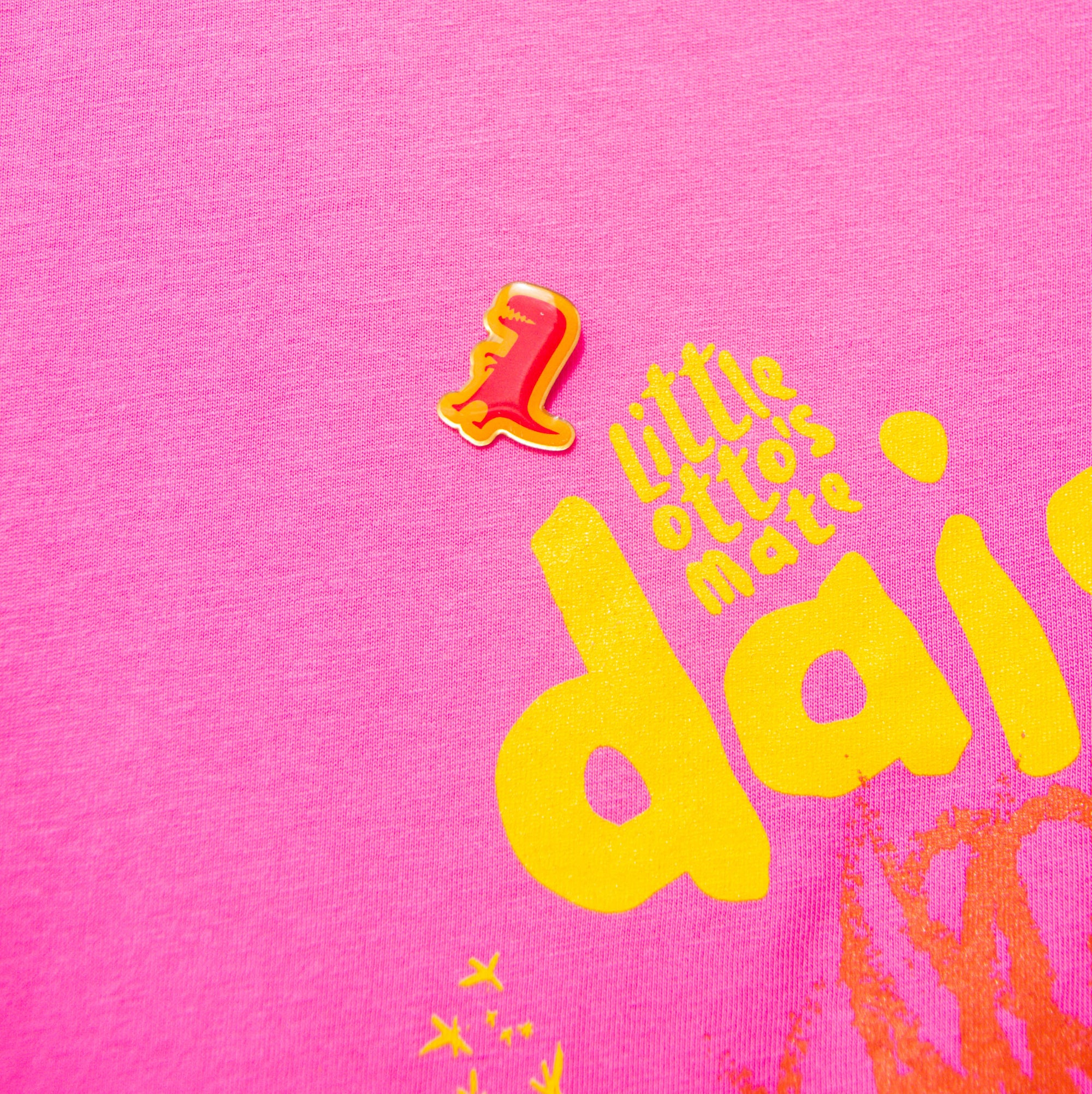 Little Otto's Staff holding Pin - T-Rex on pink tshirt 