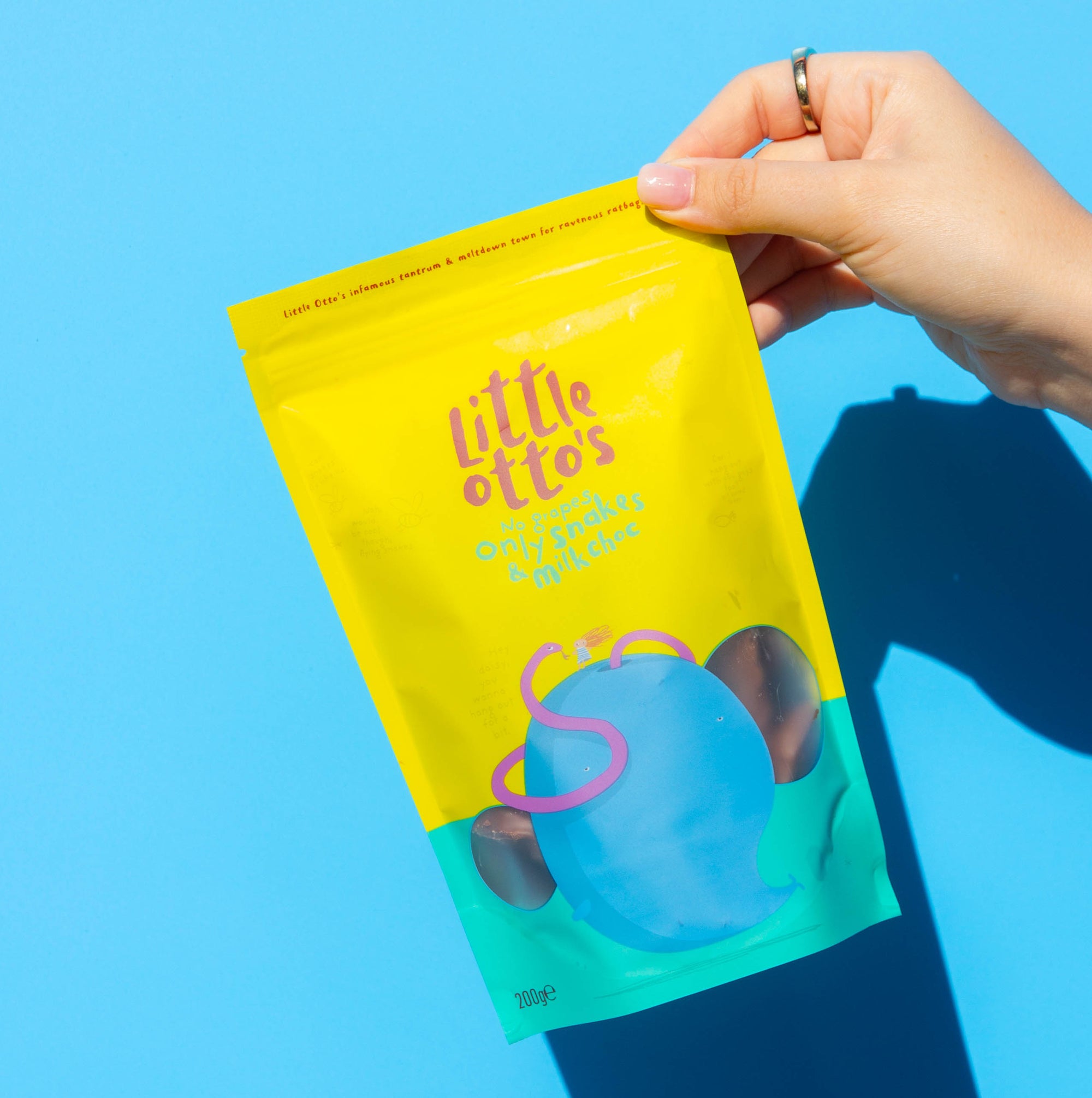 Little Otto's Staff holding only snakes in milk choc infront of Busselton blue wall