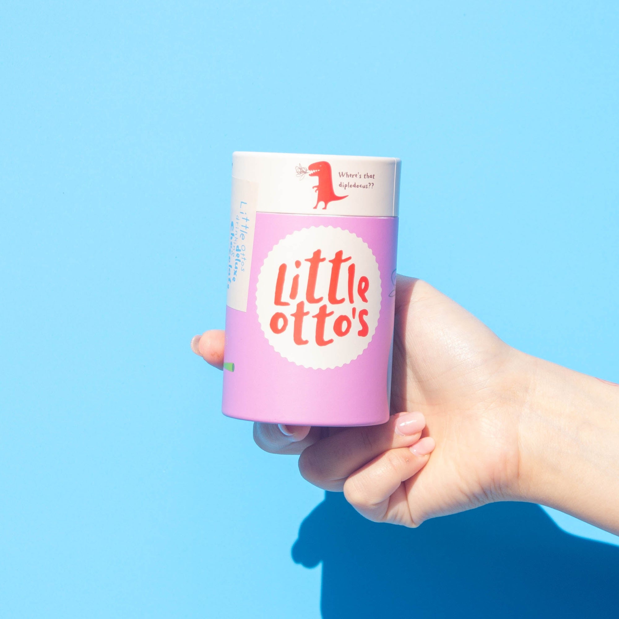 Little Ottos staff holding Deluxe Drinking Chocolate 200G infront of Busselton blue wall
