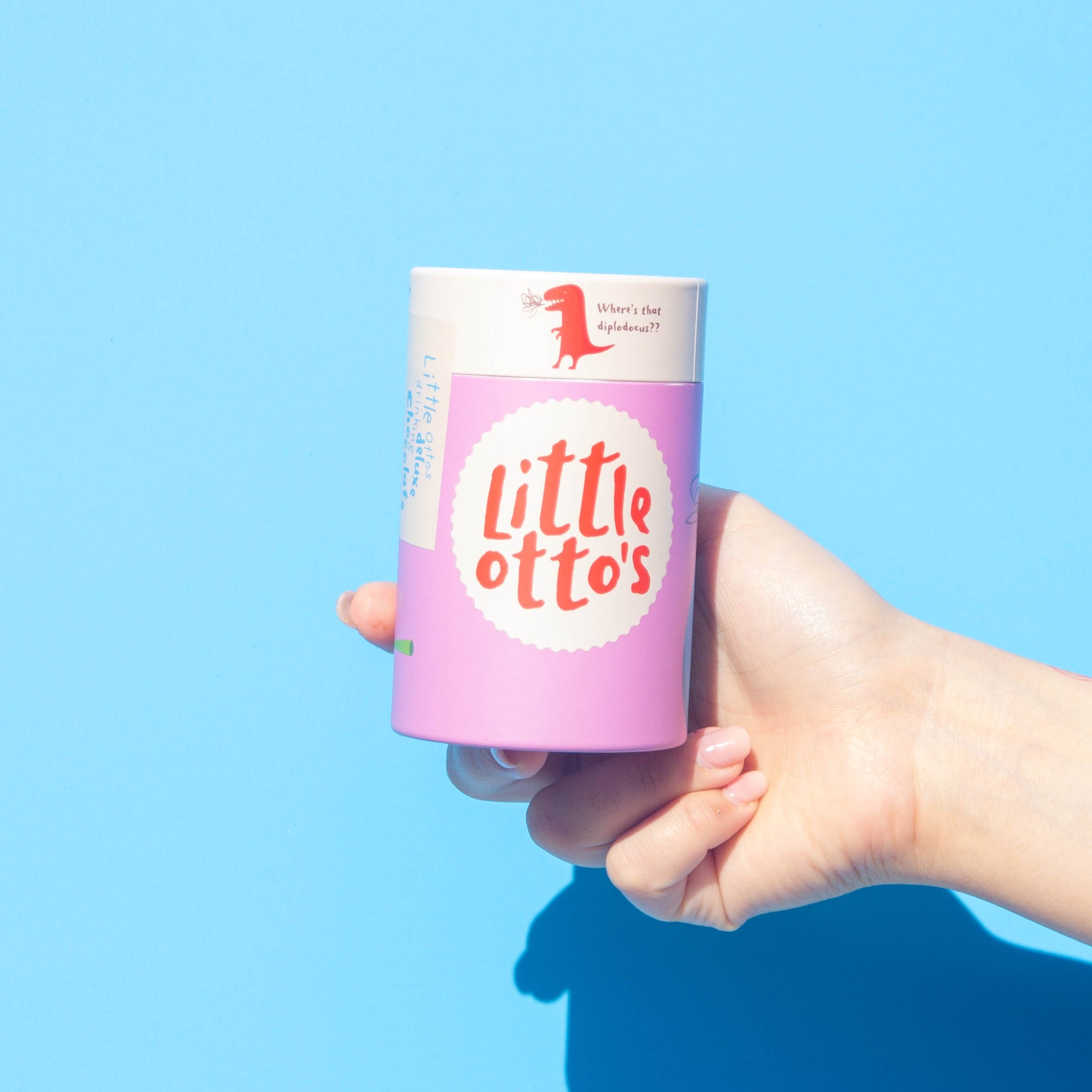 Little Ottos staff holding Deluxe Drinking Chocolate 200G infront of Busselton blue wall